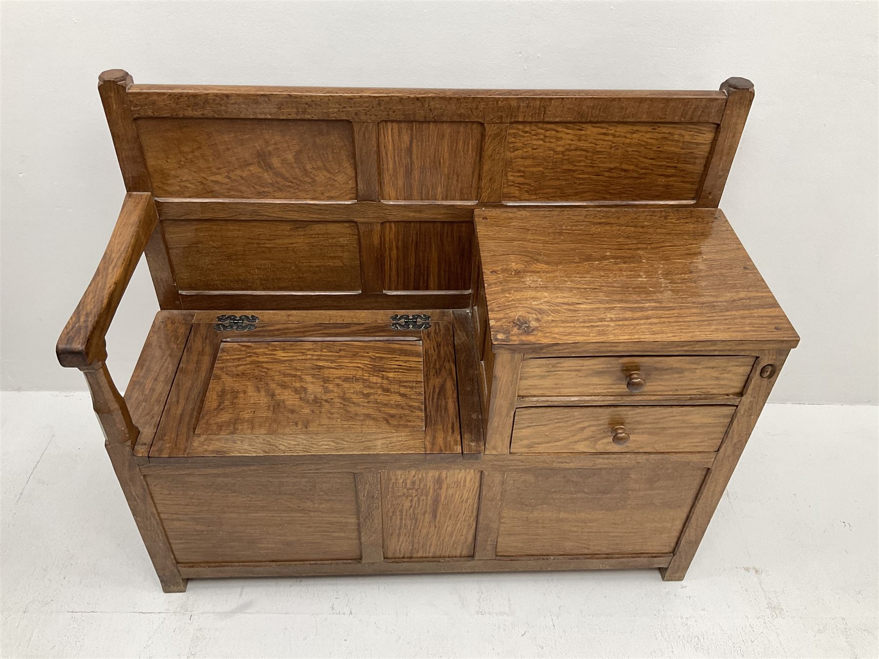 'Acornman' figured oak telephone table, panelled back above hinged seat and two drawers, panelled sides and front, all over adzing, by Alan Grainger of Brandsby, York