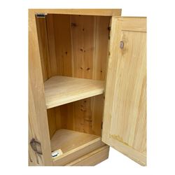 Early 20th century pine corner cabinet, projecting cornice over three shaped shelves, base fitted with single door enclosing storage space with a recessed panel, fluted sides, on plinth base