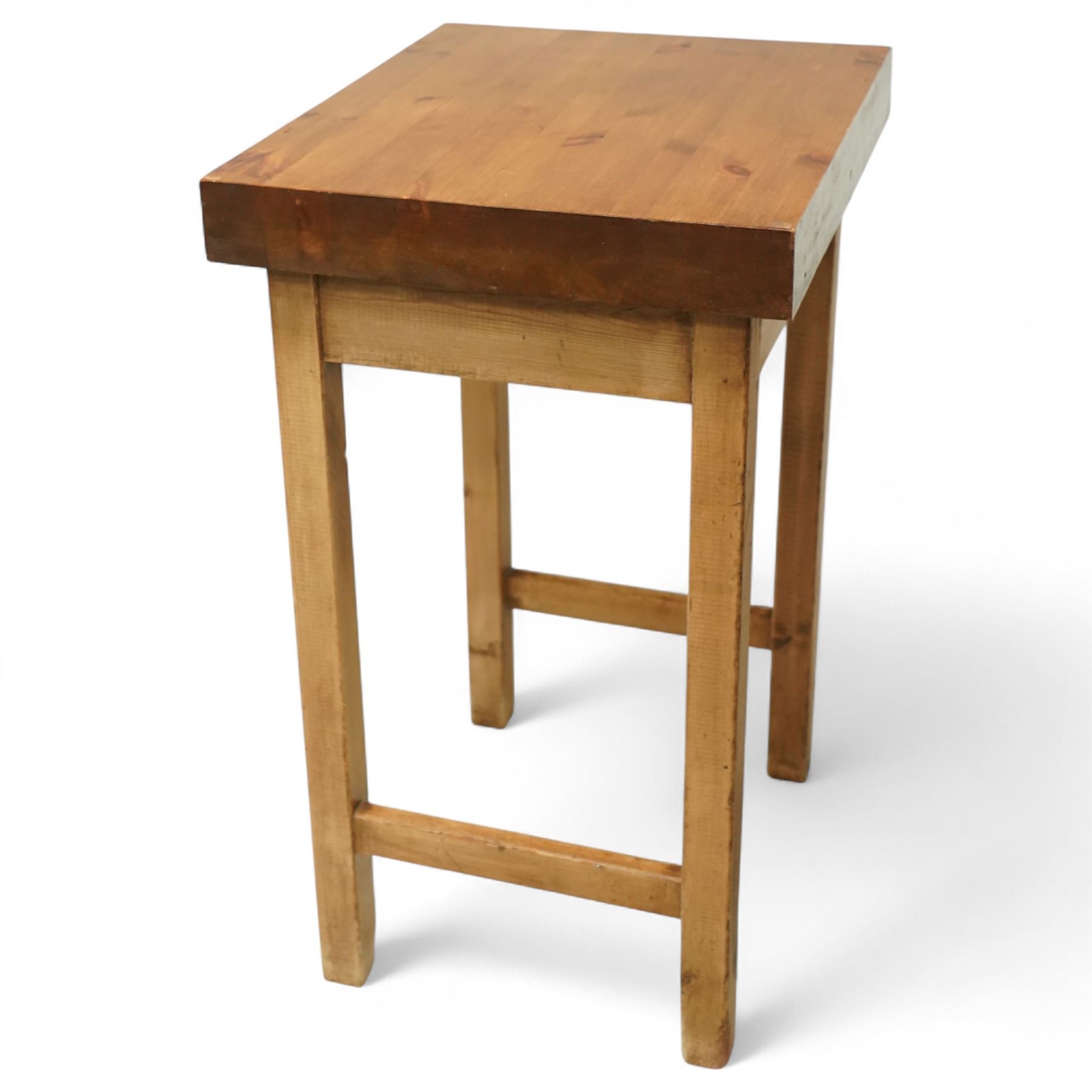 Mid-20th century pine butcher’s block, the thick laminated rectangular top raised on square supports united by side stretchers