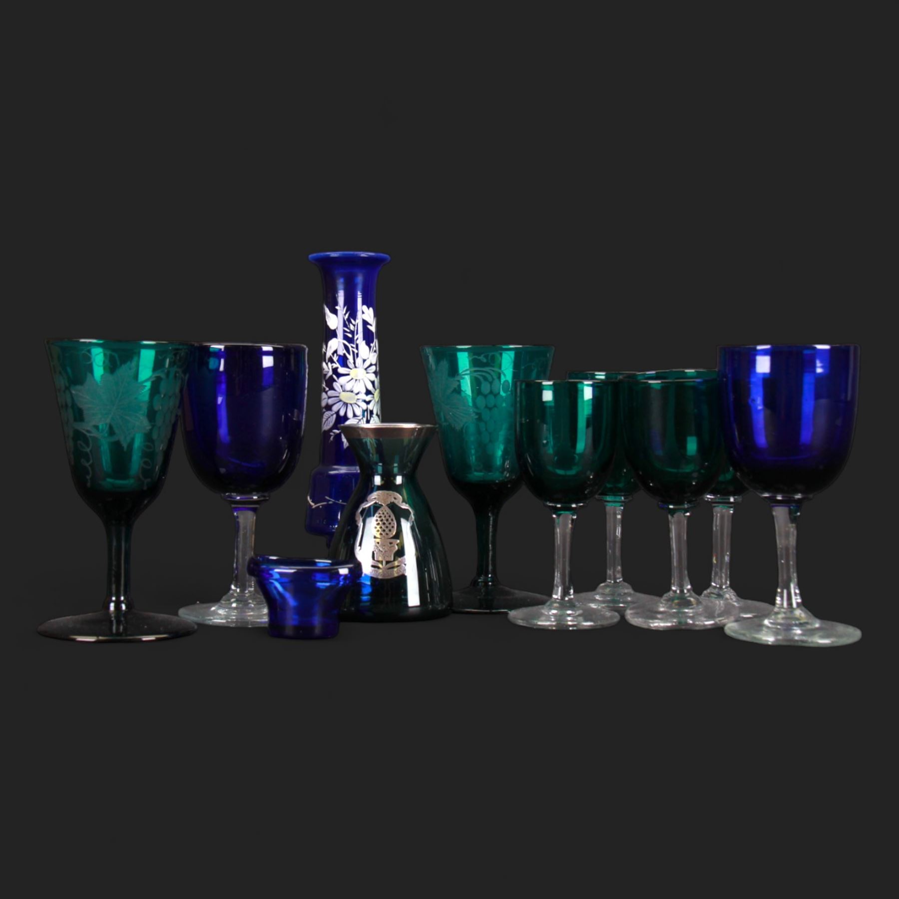 Pair of etched green glasses decorated with grapes and vine leaves, together with  blue glasses and other coloured glassware 