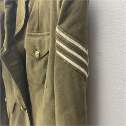 WW2 British female ATS Sergeant's service uniform grouping, consisting of four pocket female pattern service dress tunic with brass ATS shoulder titles and general service buttons; cloth lined interior with the original printed size label dated 1942; the matching khaki service dress skirt; and Greatcoat with size label dated 1945; together with army knitted sleeveless V-neck jumper; WRAC tunic, skirt and overcoat; full length cream and gold thread military evening dress by Hilliers Couture; and four webbing belts