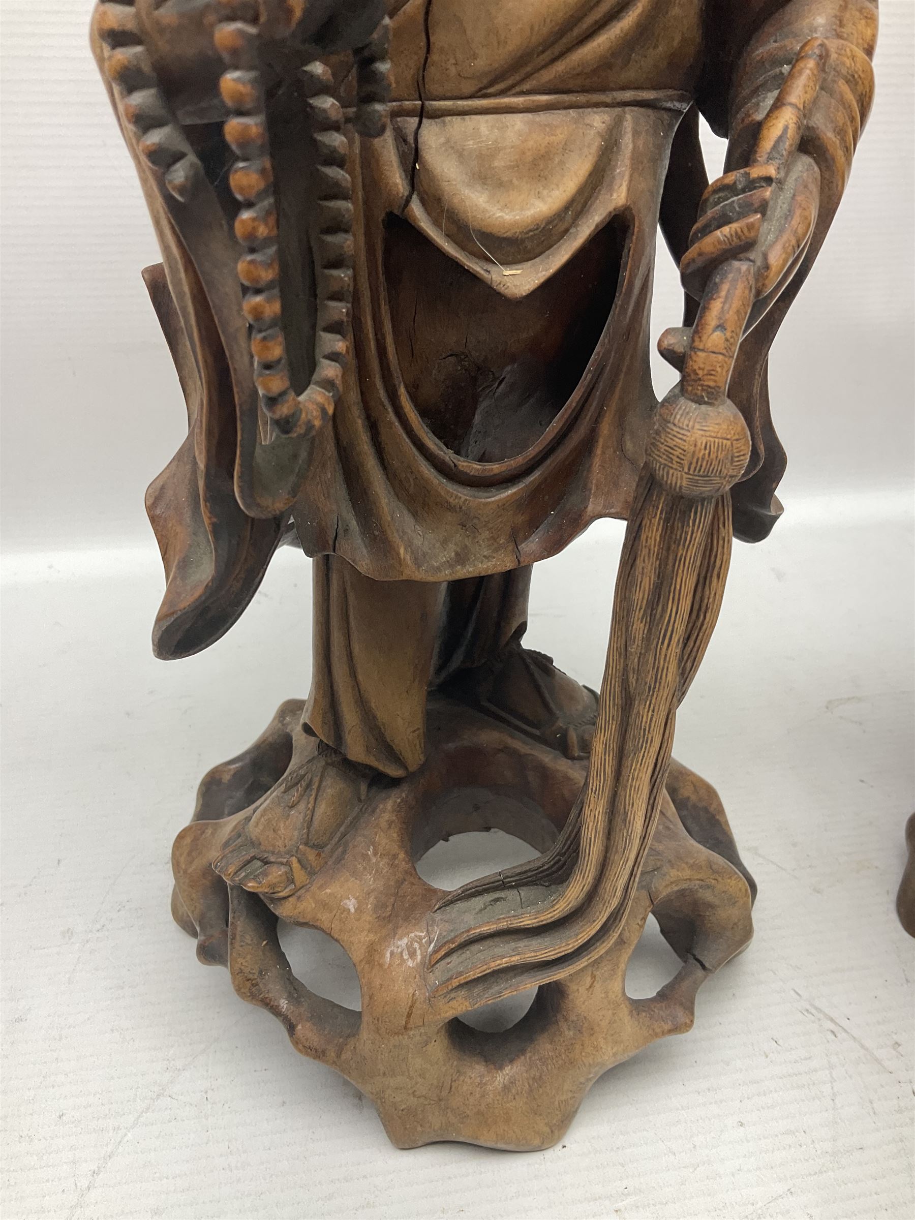 Pair of Japanese carved wooden figures, modelled as merchants in traditional dress, upon pierced naturalistic bases, tallest H39cm