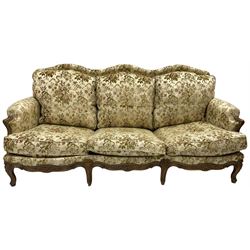 Early 20th century French carved stained beech framed three piece suite, comprising two deep seated armchairs (W76cm D93cm H87cm) and serpentine back three seat sofa (W195cm H87cm), upholstered in ivory ground floral patterned fabric with studwork, raised on foliate carved cabriole supports