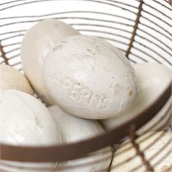 Wire crock containing 11 broody hen ceramic dummy eggs, two marked 'Caperns' 