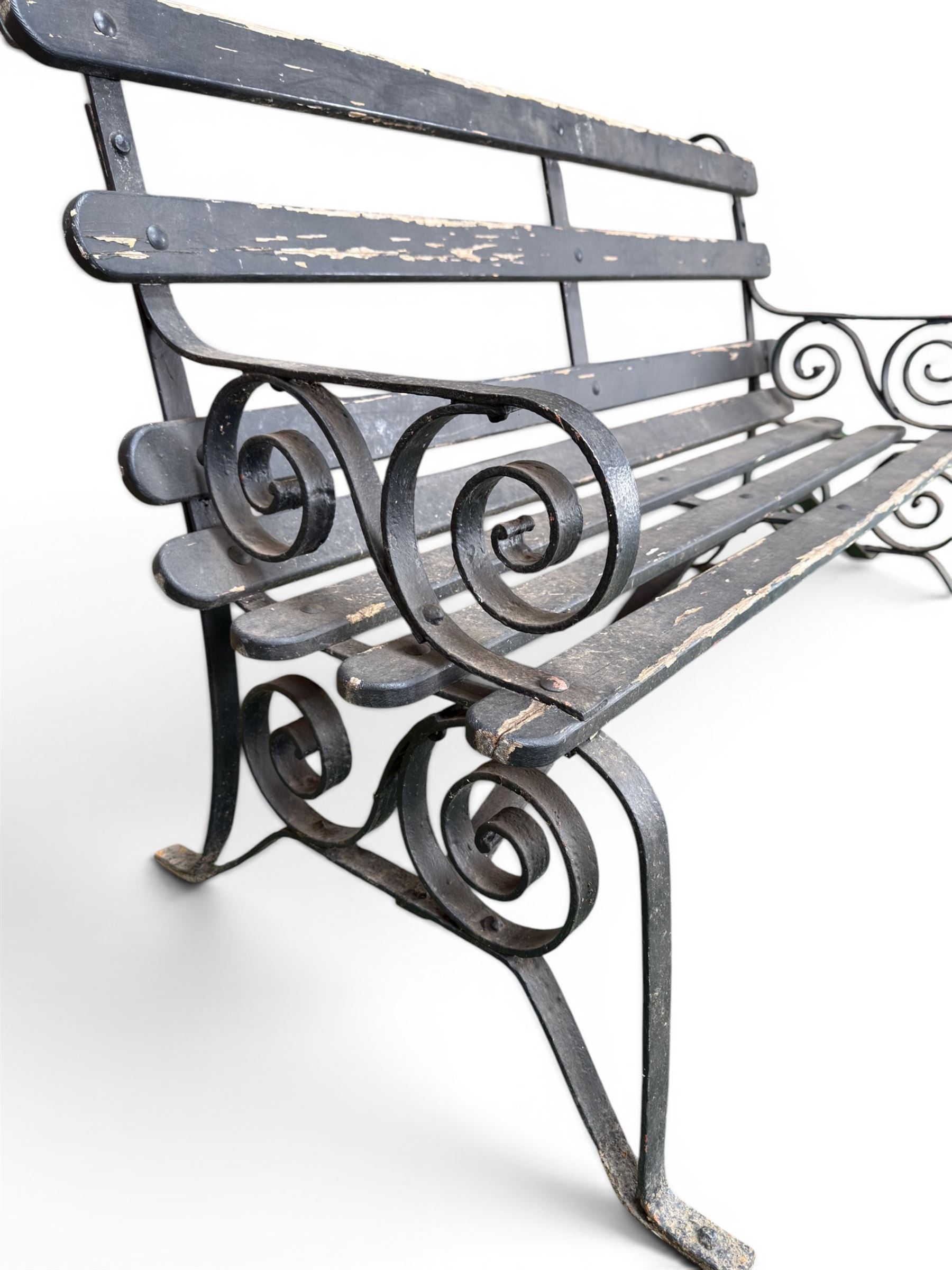 Coalbrookdale - rare pair of wrought iron and slatted wood garden benches, the twin wrought iron strapwork bench-ends formed of four scrolls over splayed feet, number 77 in the Coalbrookdale Castings Catalogue (see illustration)