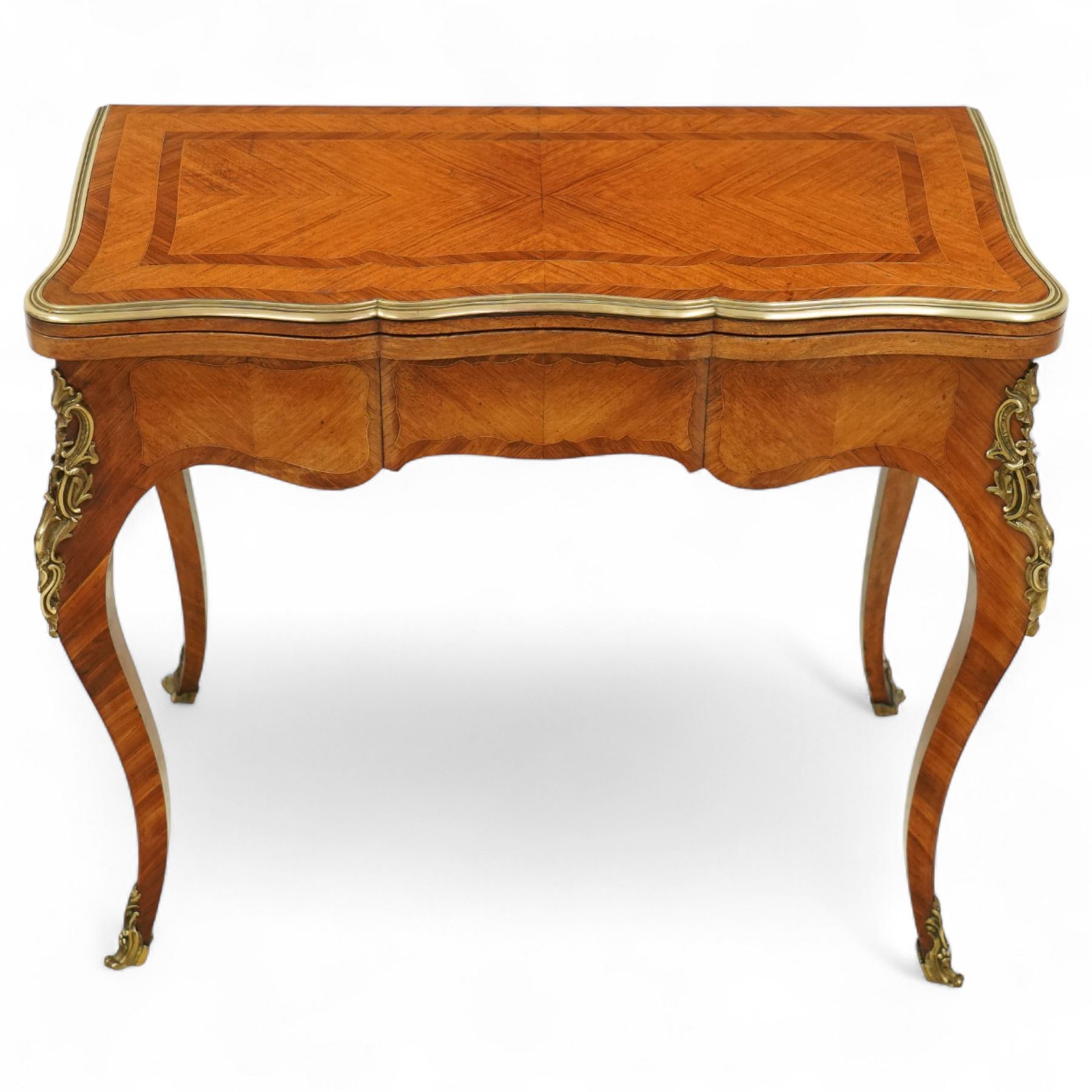 Early 20th-century Louis XV-style kingwood and tulipwood marquetry card table, shaped rectangular hinged top revealing baize-lined interior, with quarter-veneered parquetry within crossbanded borders and mounted with a gilt bronze edge, above a serpentine frieze,  raised on cabriole legs with gilt bronze foliate mounts and sabots 