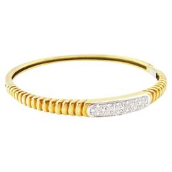 18ct gold diamond hinged bangle, set with nineteen single cut diamonds on a tapered ribbed...