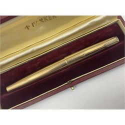 Three rolled gold Parker fountain pens, comprising an example with a gold nib marked 14K 585 and barrel with a shell stamp, a Parker 61 fountain pen with inset gold arrow to the nib, and another similar, all with striated decoration and arrow clips to the caps, L13cm, one with box