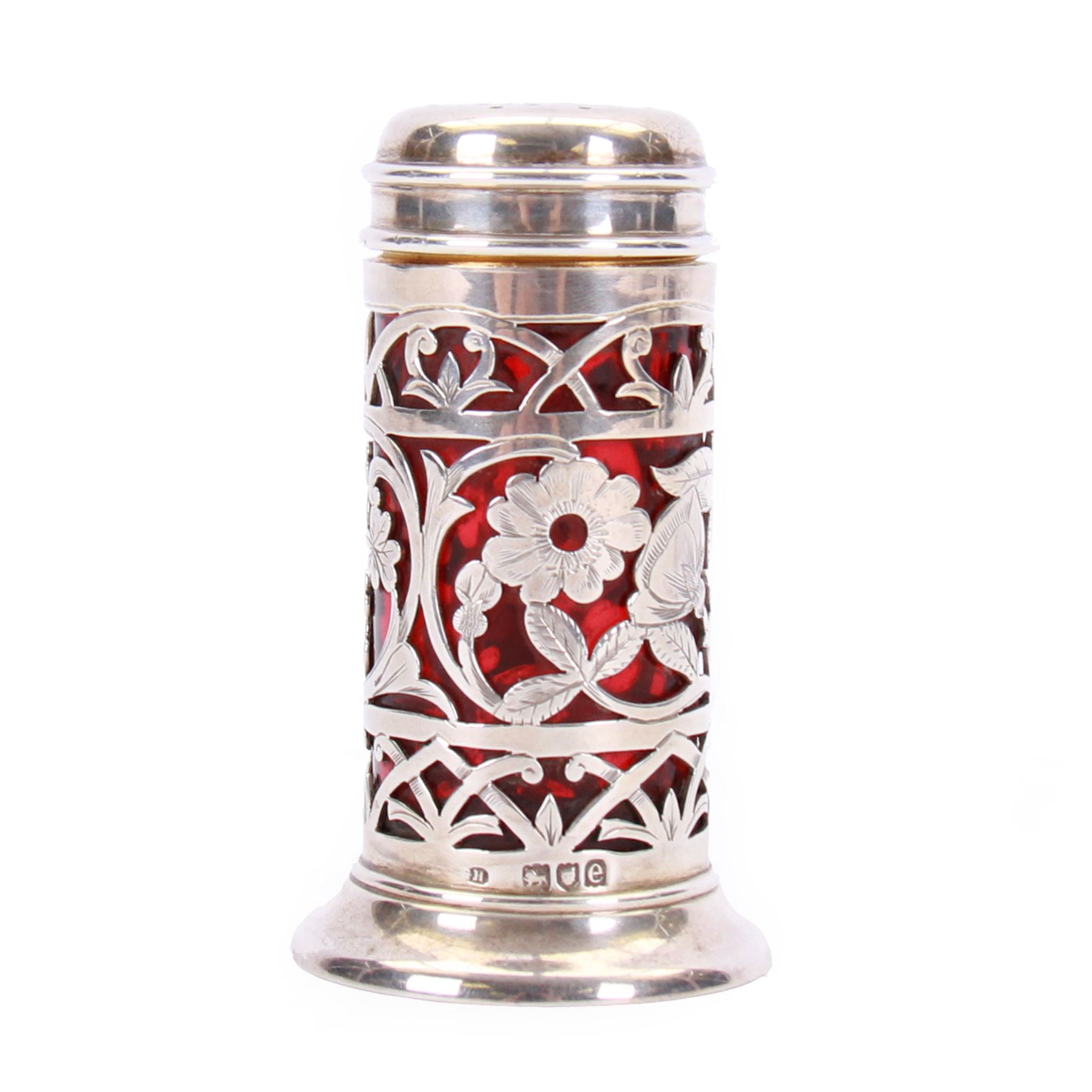 Late Victorian silver pepper, of cylindrical form with screw threaded pierced flat topped cover, the openwork body decorated with flowers of the Union, roses, thistles and shamrocks, revealing a ruby glass liner, upon a spreading circular foot, hallmarked Harrison Brothers & Howson, London 1900, H8cm