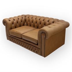 Contemporary tan leather chesterfield settee, deep button upholstered throughout with rolled arms and back of equal height, brass stud detailing, twin seat cushions