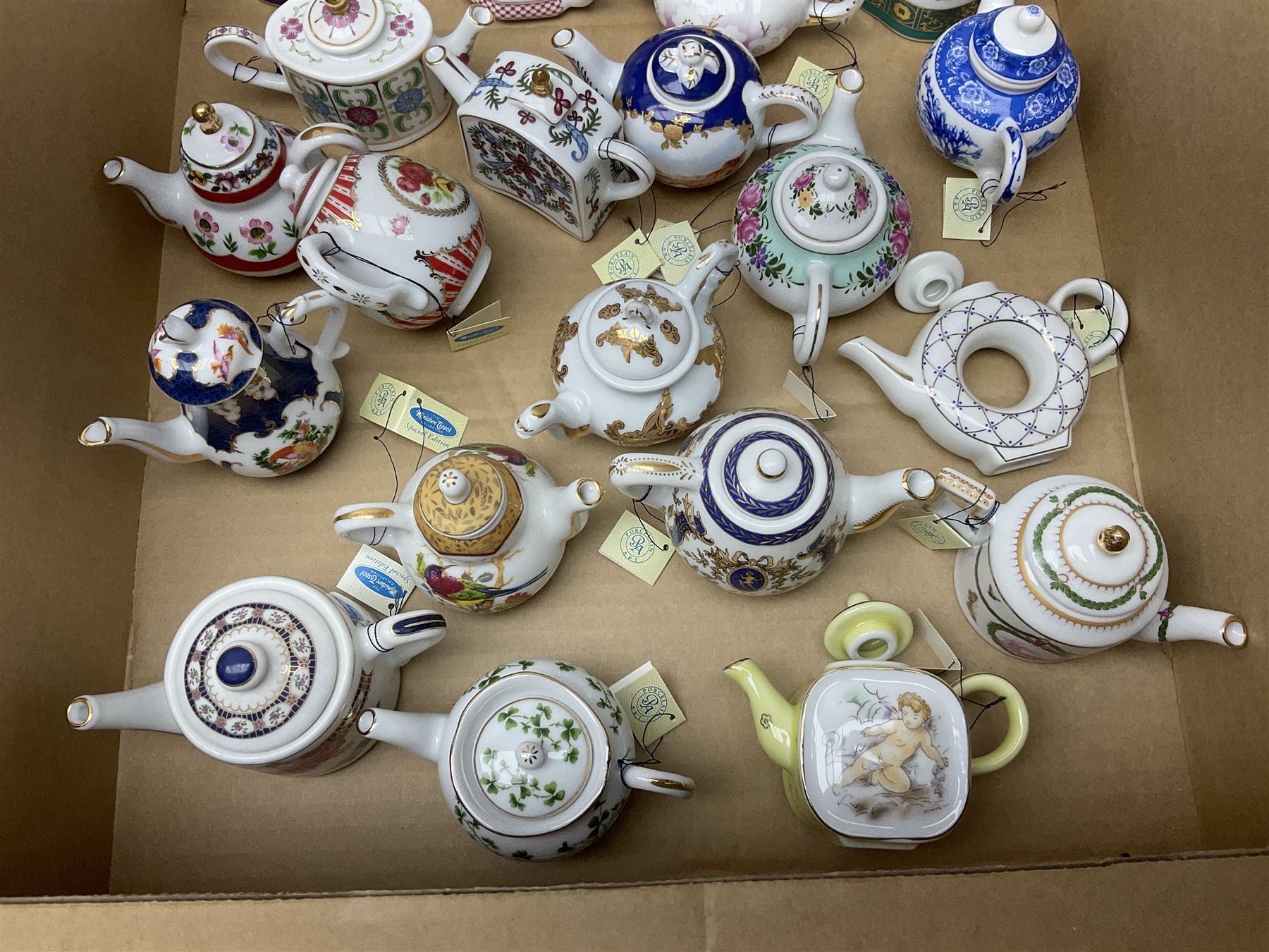 Twenty seven Porcelain Art miniature teapots, with wooden display together with a collection of other ceramics and glassware etc, including Goebel Hummel collectors plates, in three boxes,
