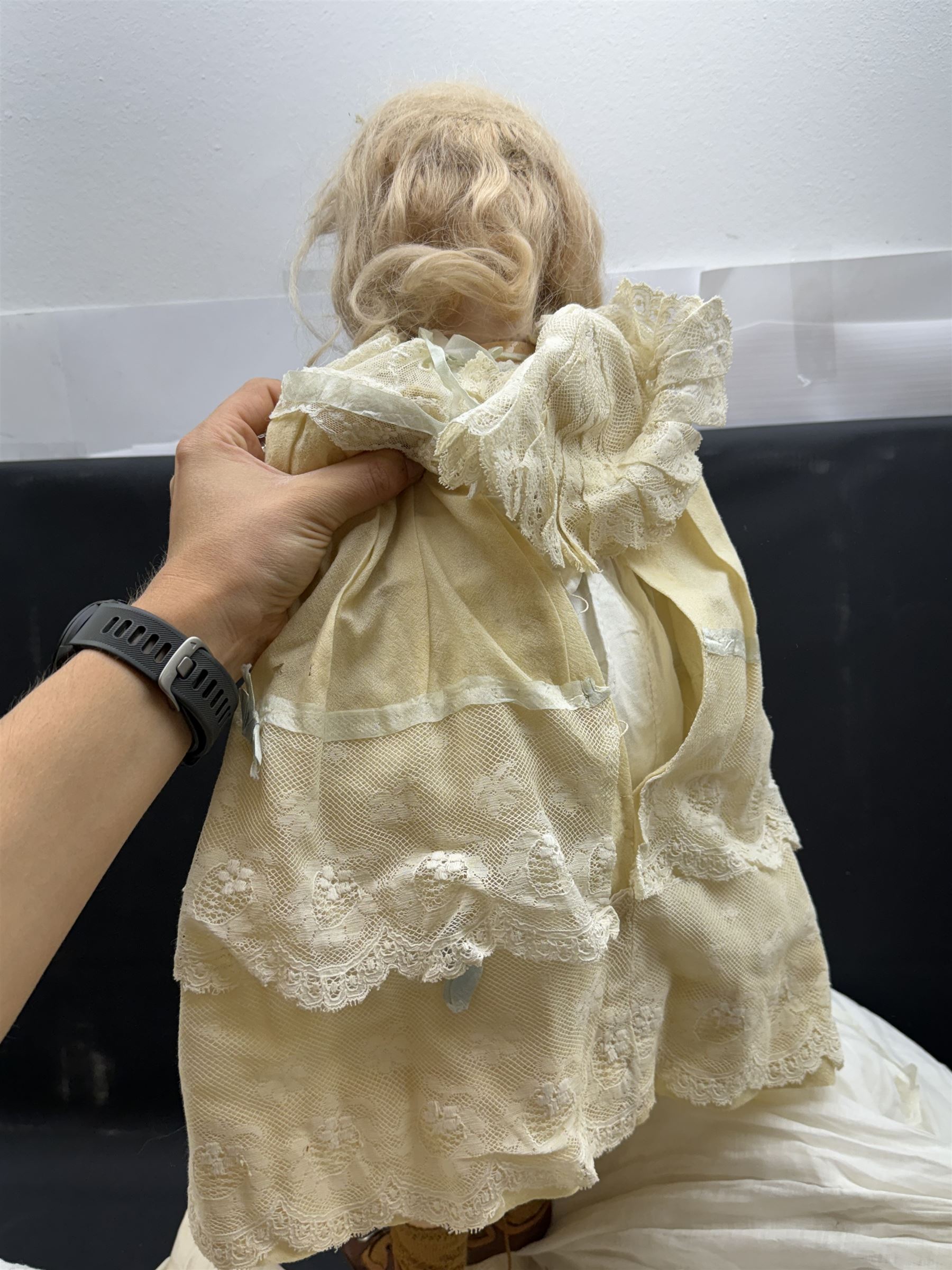 Two German bisque head dolls, to include a Franz Schmidt example with blue glass eyes and an Armand Marseille 590 example with applied hair, together with a Schoenau & Hoffmeister bisque doll's head, pair of doll's hands and a collection of clothing