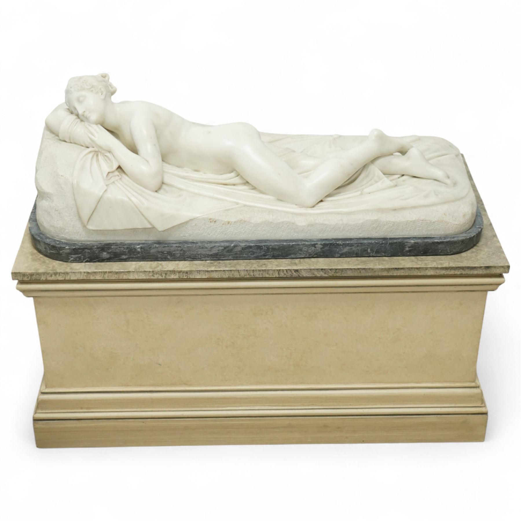 After Antonio Canova (Italian 1757-1822): 'Sleeping Venus', an Italian carved white marble figure of a reclining nude, the serene figure depicted lying on her side, her head resting on a cushion and one knee gently raised, a loosely draped sheet partially covering her lower body, on a rectangular base with rough-hewn surround, raised on a marble plinth over a sarcophagus style pedestal, circa 1900

Provenance: Kirkham Hall

Notes: A late-19th-century homage to Canova’s neoclassical models, reflecting the Grand Tour taste for idealised classical beauty and the refined finish characteristic of Italian workshop marbles of the period