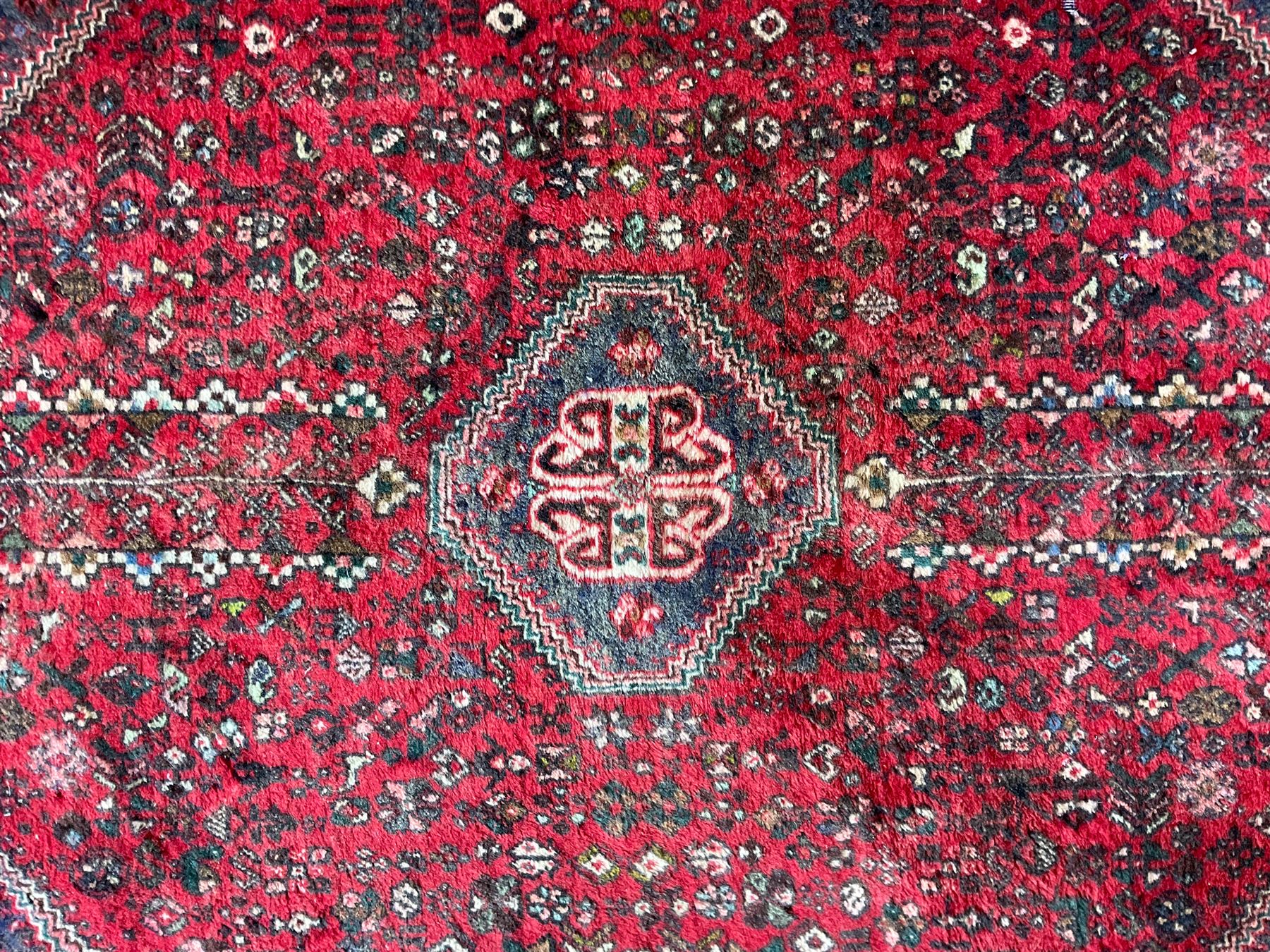 Persian Kashan crimson ground rug, hexagonal field decorated with central medallion and surrounding bird plant and animal motifs, guarded border with repeating floral and bird design