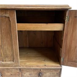 19th century pitch pine squat linen press, two panelled doors enclosing slide, fitted with two short and one long drawer, scroll wrought metal handles, on skirted base  