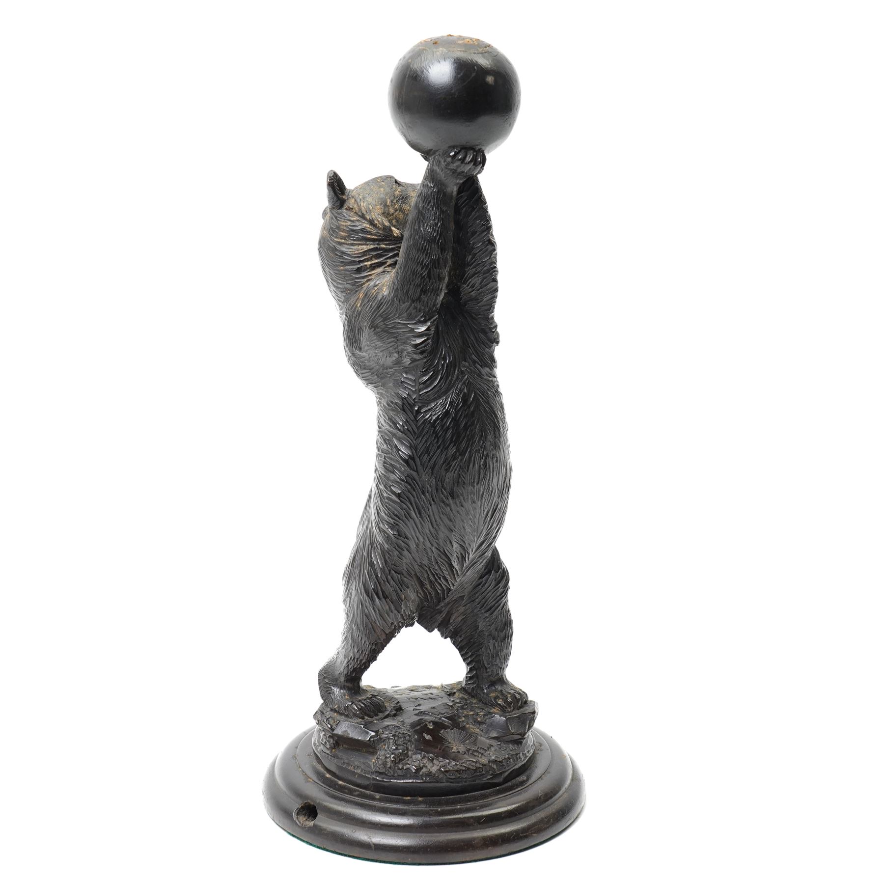 Black forest carving of a circus bear, holding aloft a ball, standing, H35cm