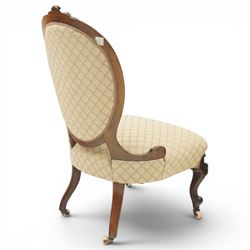 Pair of Victorian walnut framed ladies salon nursing chairs, oval cameo back with carved cartouche carved cresting rail, sprung seat upholstered in foliate patterned ivory fabric, shaped apron carved with scroll and cartouche decoration, on cabriole supports with moulded flower knees, retailed by David Hick Interiors, Jersey