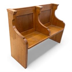 Pair of mid 20th century oak ecclesiastical pews, each with panelled backrests and shaped end supports, of solid construction and mellow honeyed tone