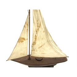 Large Victorian pond yacht, the planked hardwood hull with large lead weighted keel and working rudder, simulated planked deck and single mast with original sails; on later scratch-built wooden stand L117cm H151cm