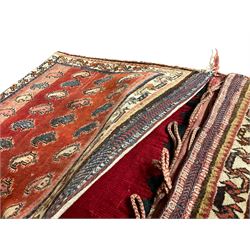 Antique Persian red ground saddle bag, decorated with all-over Boteh motifs, geometric patterned border (127cm x 68cm); Persian indigo ground saddle bag, decorated with two geometric ivory lozenges (113cm x 62cm); Persian red ground saddle bag decorated with lozenges and multi-band border (110cm x 65cm) 