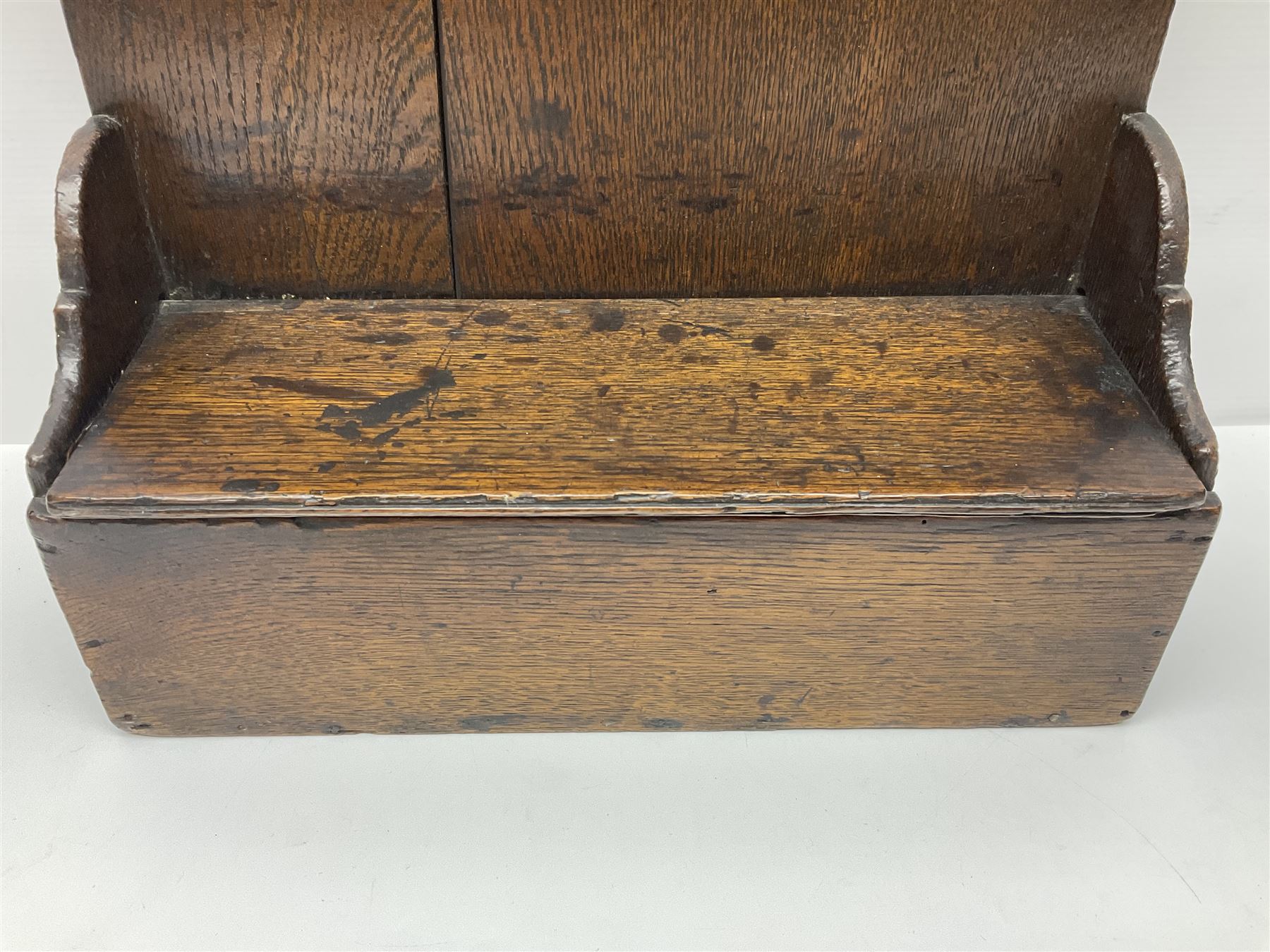 George III oak spoon rack and candle box, the rectangular backplate with shaped  pediment and two six aperture spoon racks, above a candlebox with hinged cover, with various brass spoons and a pair of brass candle snuffers, H56.5cm, W35cm, D14cm 