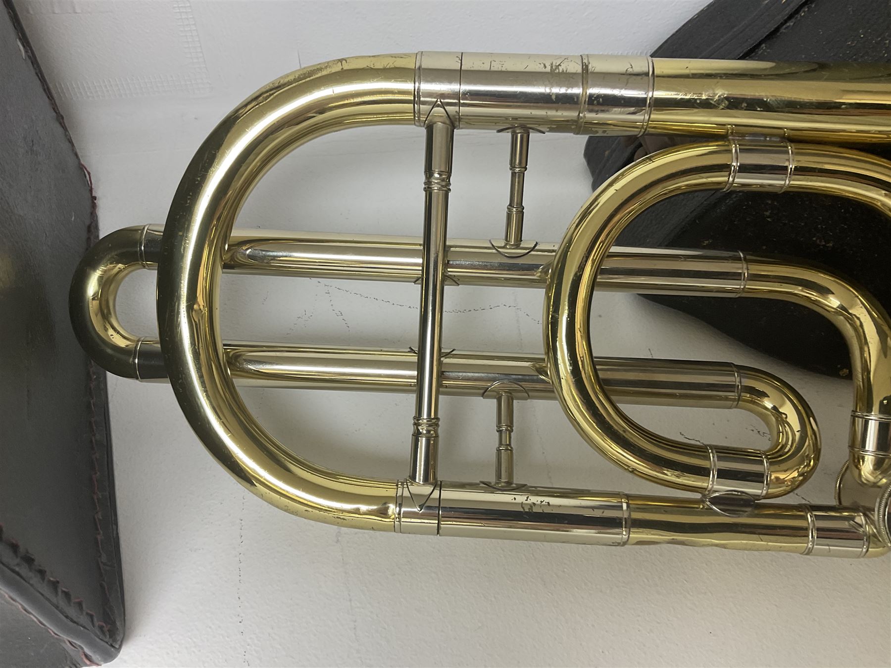 Three brass trombones comprising Elkhart Ind. USA 'CONN' model no.72H; Besson 'Concord'; and Selmer Distributed 'Lincoln'; two in carrying cases; and German B & M 'Champion' brass trumpet (4)