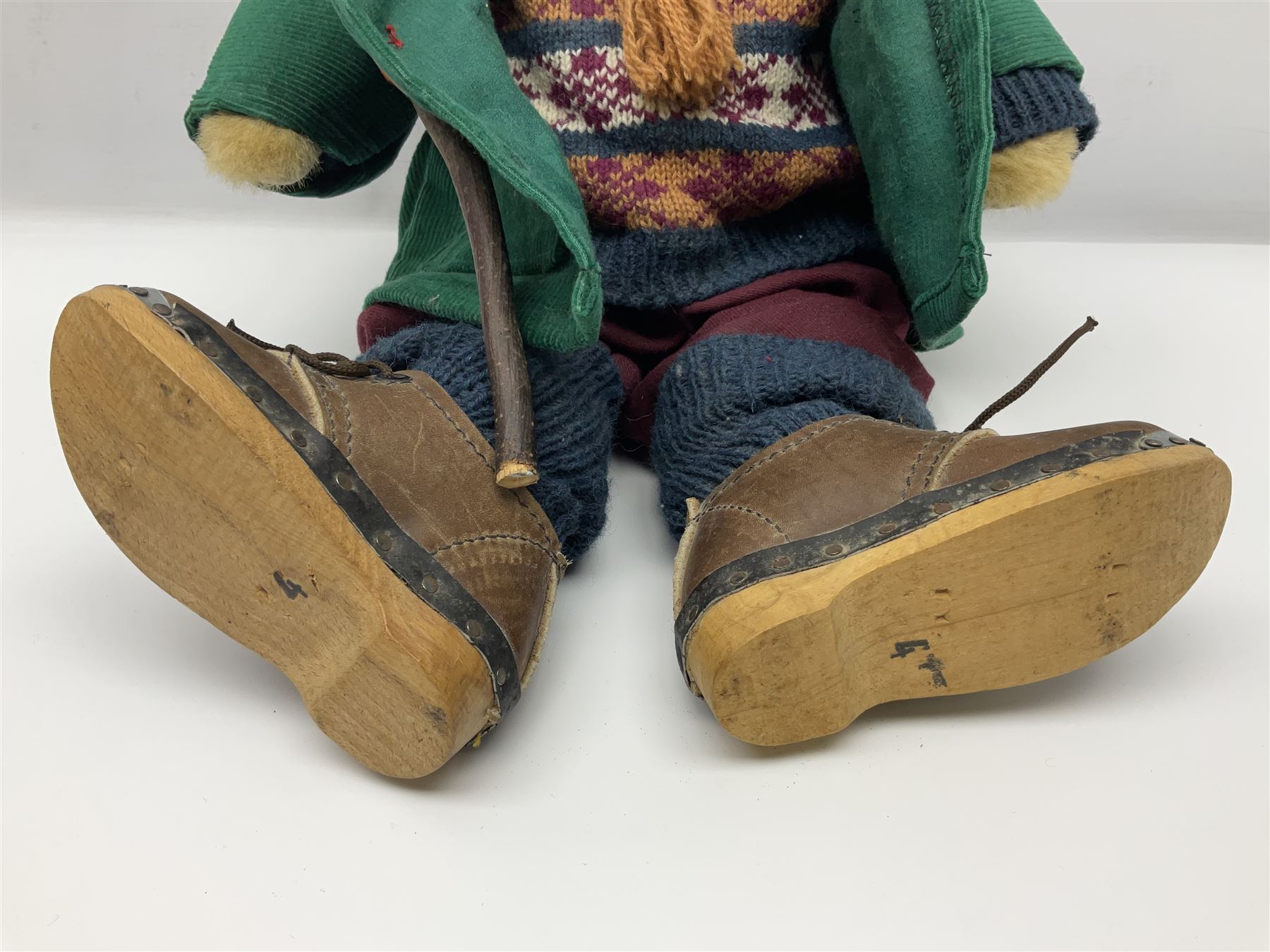 Lakeland Bears teddy bear, titled 'Walkright', dressed as a hiker in green corduroy duffle coat over fair isle jumper, trousers and knit socks, complete with leather clogs with wood soles, walkers thumb stick, knitted scarf, flat cap and rucksack housing original tag and map, H50cm