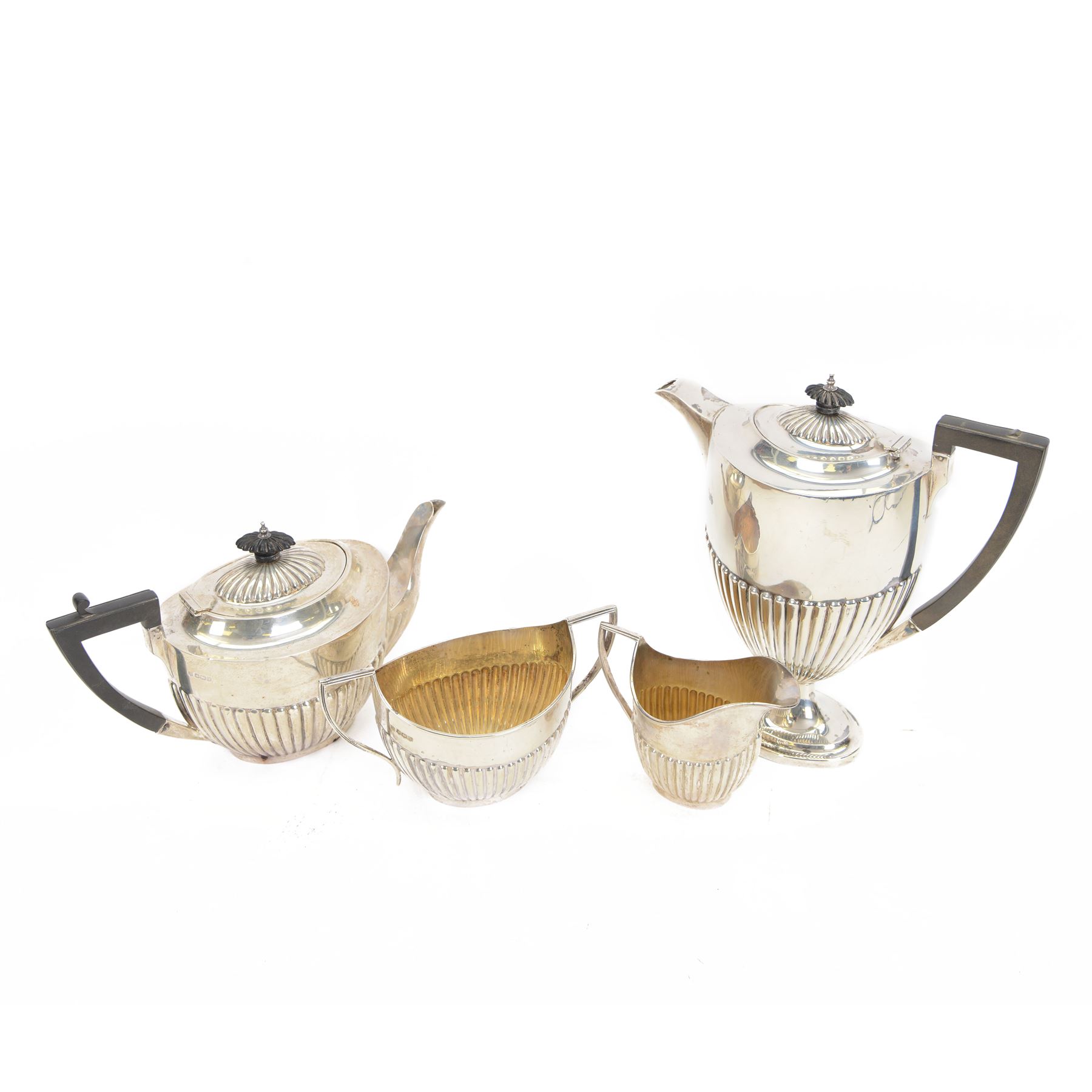 Early 20th century four piece silver tea service, comprising teapot, hot water pot, open sucrier and milk jug, all of oval part fluted form, the teapot and hot water pot with Bakelite type handles and finials, hallmarked James Deakin & Sons (John & William F Deakin), Sheffield 1918
