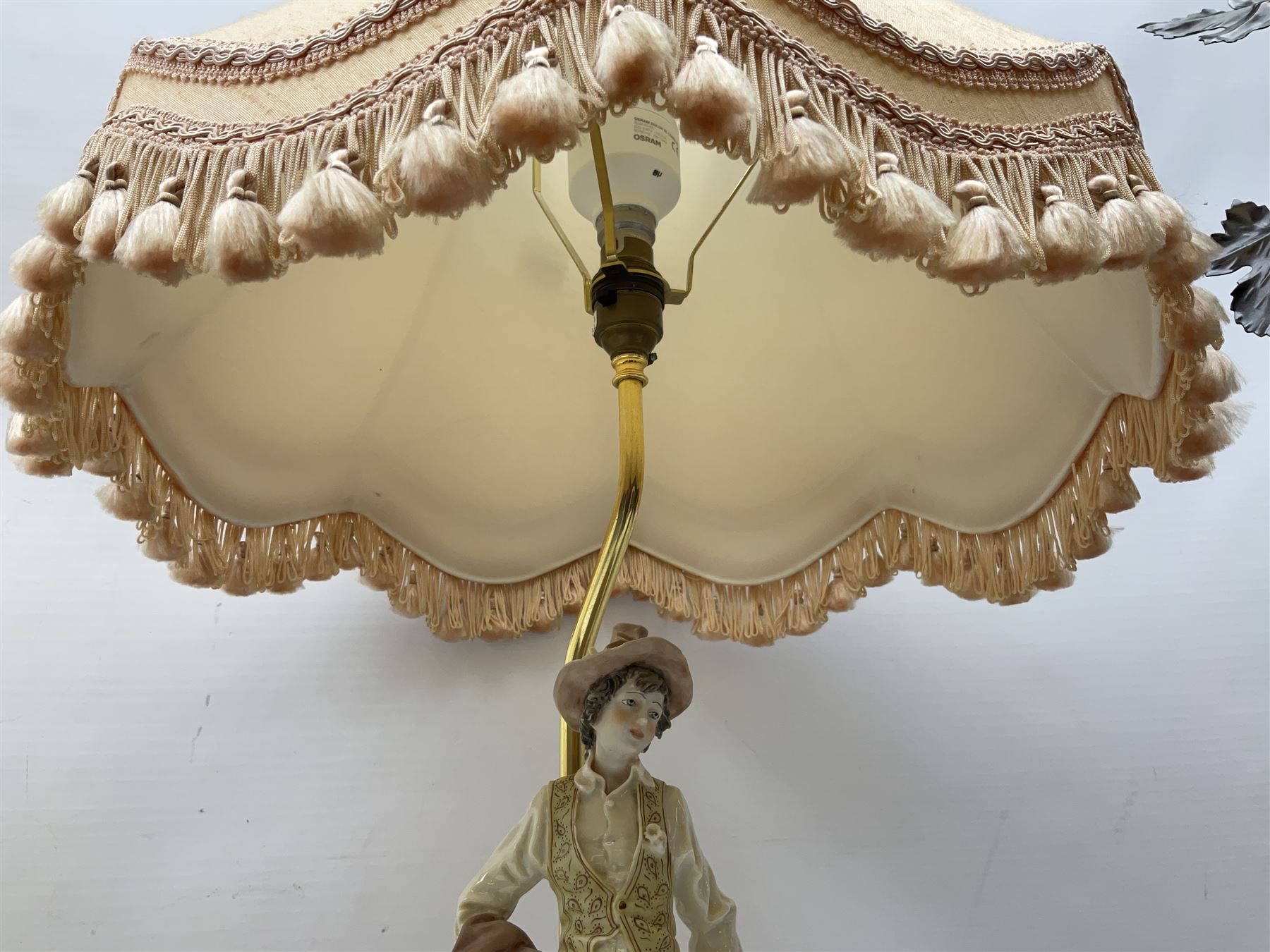 A Belcari figural table lamp, modelled as a young gent leaning upon brick wall, on turned wood base, signed, H70cm incl shade, together with bronzed figural table lamp of a lady with parasol upon ornate circular plinth base, two ceramic table lamps and another lamp (5)