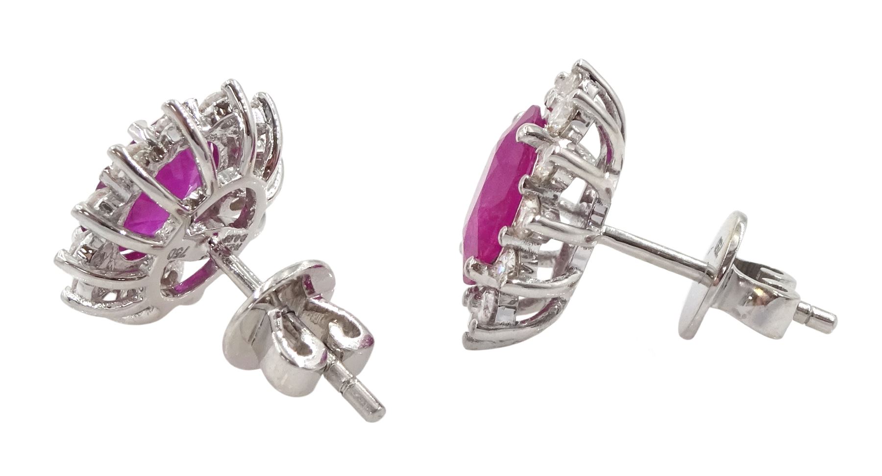 Pair of 18ct white gold ruby and diamond cluster earrings, each stud set with a single oval cut ruby and twelve round brilliant cut diamonds, stamped 750, total ruby weight approx 2.30 carat, total diamond weight approx 0.50 carat