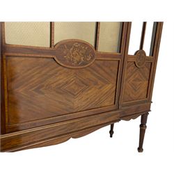 Edwardian inlaid mahogany display cabinet on stand, the stepped and shaped top with moulded cornice over frieze inlaid with floral garlands, central door and front astragal glazed with satinwood slips and panelled with quarter veneers, oval panels inlaid with flowers and birds, on acanthus carved and fluted supports