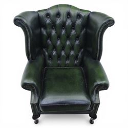 Late 20th century green leather chesterfield style wingback armchair, with deep buttoned back, scrolled wings and arms with studded borders, loose seat cushion, raised on cabriole legs
