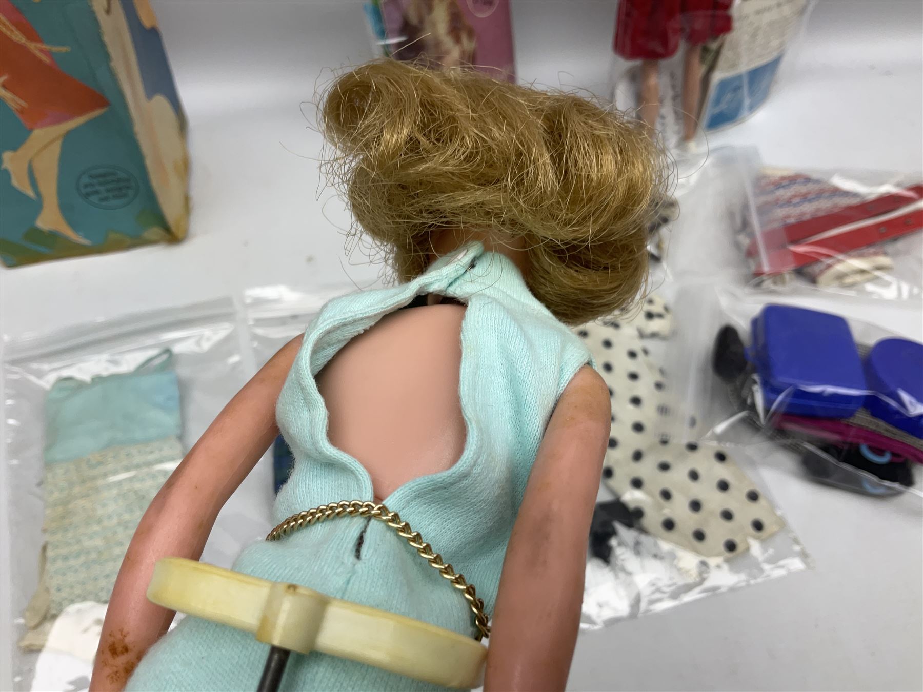 1960s Palitoy Tressy fashion doll, boxed with stand and booklets; four additional Tressy outfits (In The Office, Winter Journey, Winter Sports and Evening Date); two other outfits; and Tressy's Little Sister Toots doll with Style Book and additional outfit