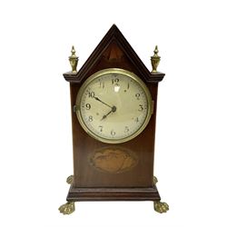 French - Edwardian 8-day mahogany inlaid mantle clock with a gable pediment and brass finials, oval inlay to the front and raised on brass paw feet, painted dial with arabic numerals and spade hands within a glazed bezel, timepiece movement with a lever platform escapement. With key.