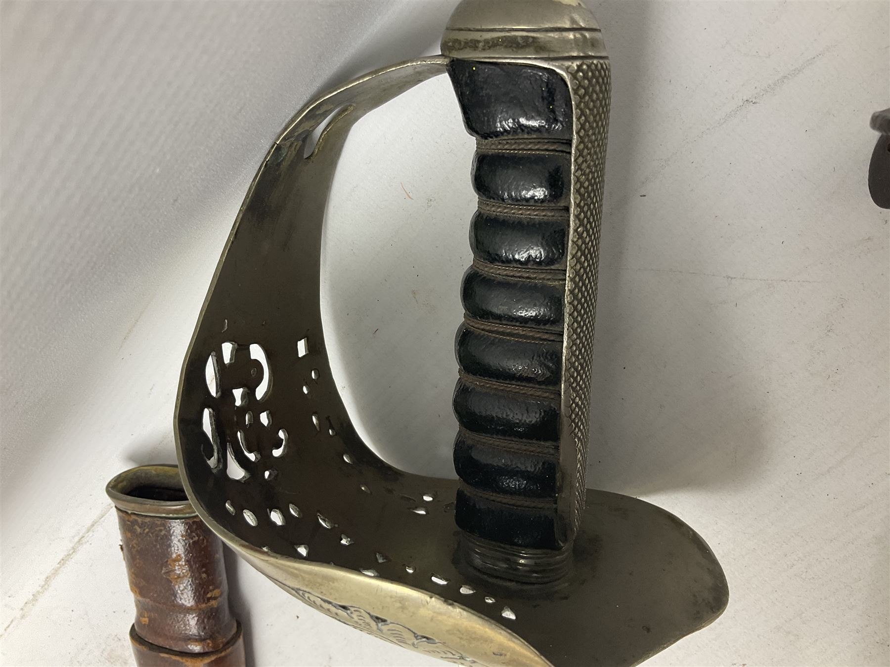 George V British Army 1897 pattern officers sword with plain 82cm fullered steel blade, pierced  basket hilt with George V cypher and wire bound leather grip with chequered backstrap; in leather covered field service scabbard L101cm overall; and another officer's sword in relic condition lacking scabbard (2)