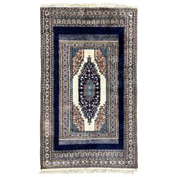 Indo-Persian indigo ground rug, the field depicting a rug with floral medallion and spandrels, enclosed within multiple floral pattern border bands