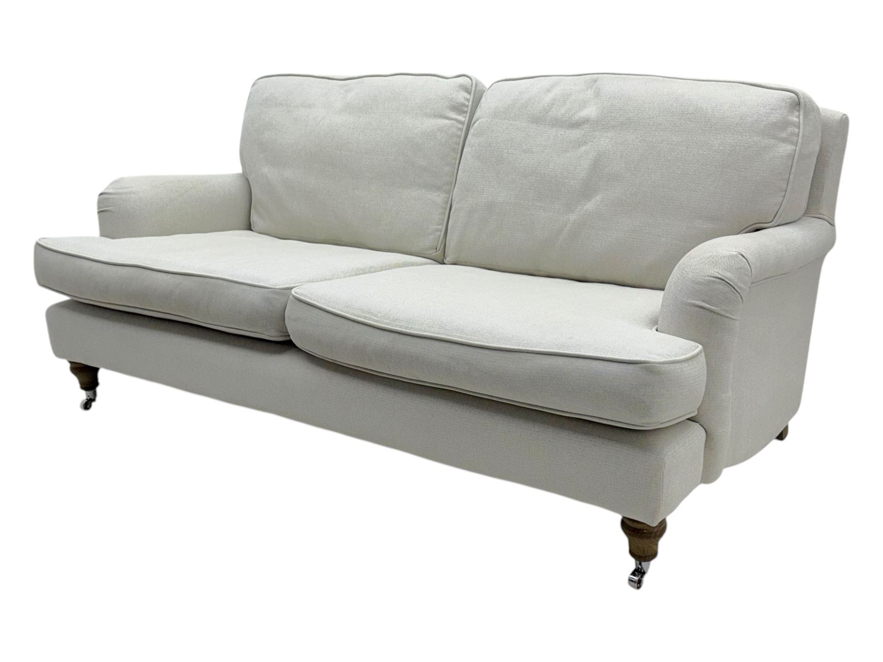 Contemporary sofa.com “Bluebell” two-and-a-half seat sofa, upholstered in pumice house basket weave linen cotton, featuring scroll arms, turned oak legs with bronze castors, and feather and fibre cushion interiors