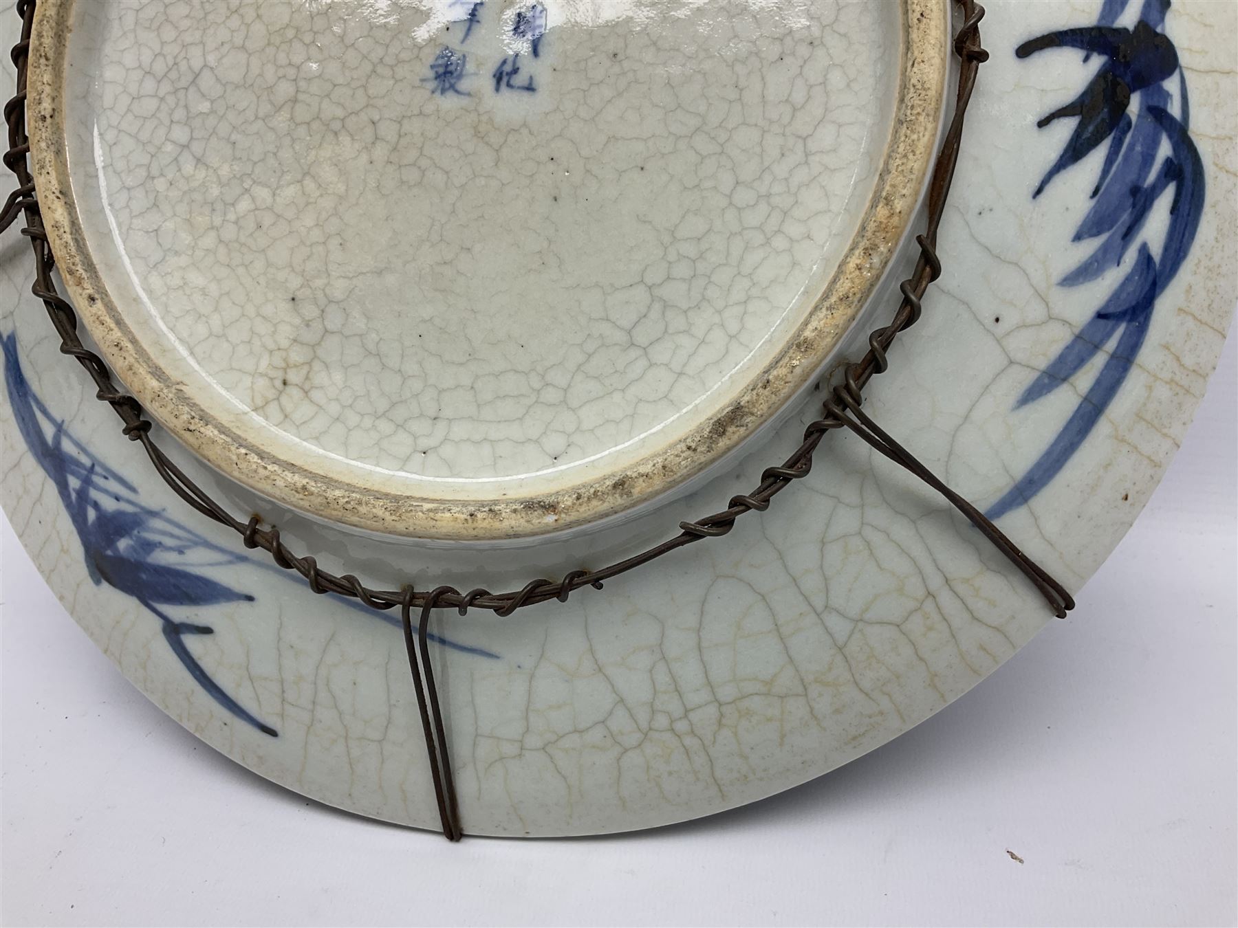 20th century Chinese blue and white crackle glaze charger, decorated with peonies, prunus blossom, and rockwork, within simulated bronze border, with character mark verso, D34cm