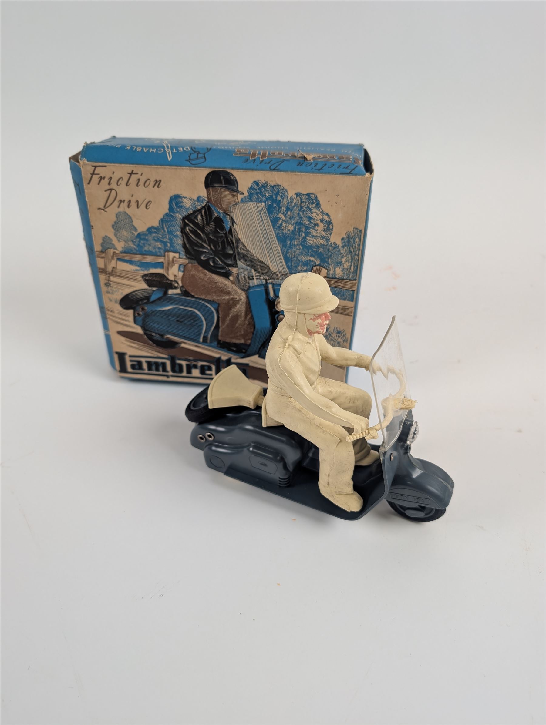 Mettoy friction drive Lambretta scooter no. 8134, the blue plastic scooter with cream handlebars and clear windshield, the rider with cream hat and clothing, stamped MTY 143 to front mud guards, in original box