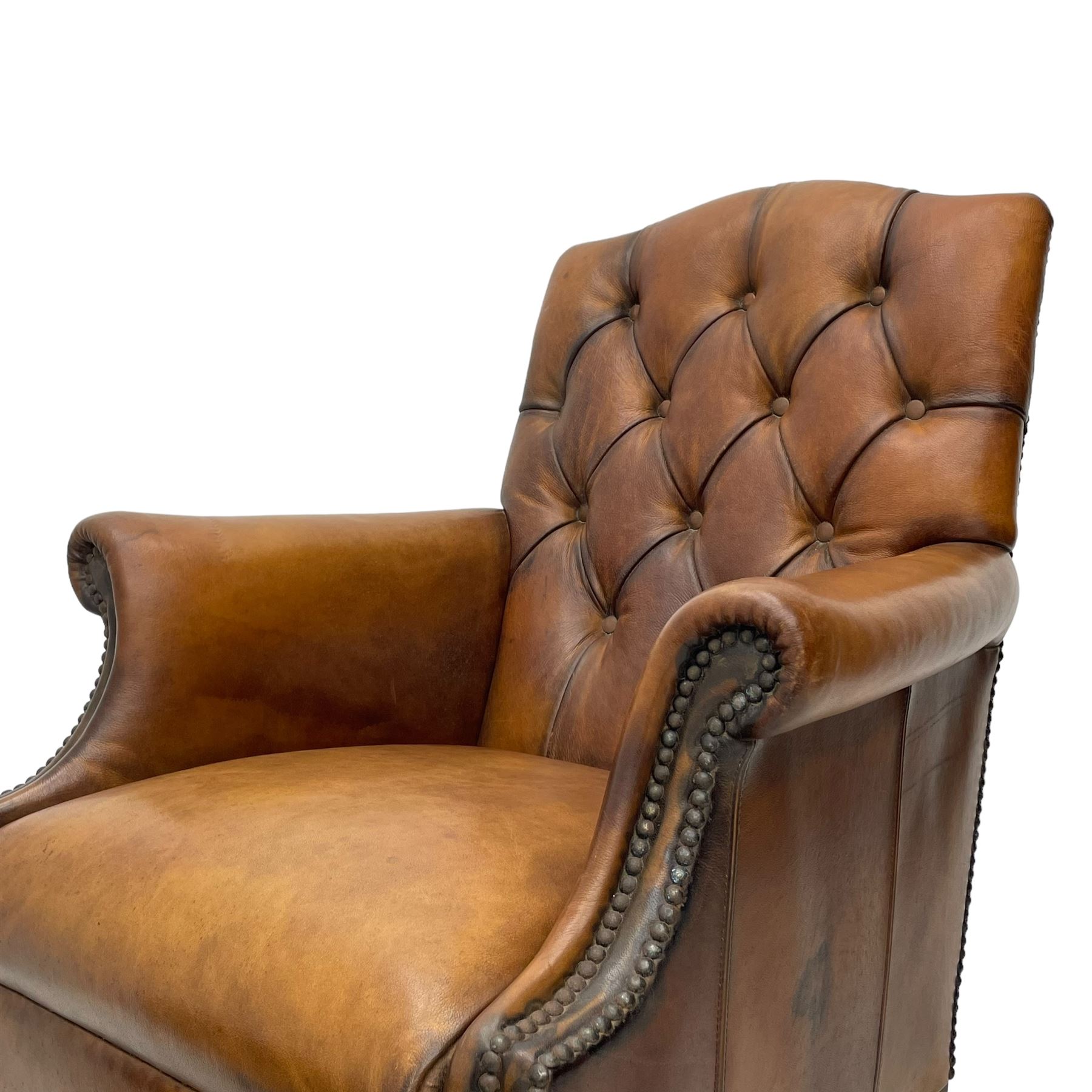 Laura Ashley - hardwood-framed armchair, traditional shape with arched cresting rail over rolled arms, upholstered in buttoned brown leather with studded work, on turned front feet (W76cm, W95cm, D84cm); together with matching rectangular footstool (53cm x 34cm, H29cm)
