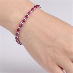 18ct white gold ruby and diamond bracelet, twenty-six oval cut rubies, each spaced by two round brilliant cut diamonds, stamped 750, total ruby weight 12.70 carat, total diamond weight 0.46 carat