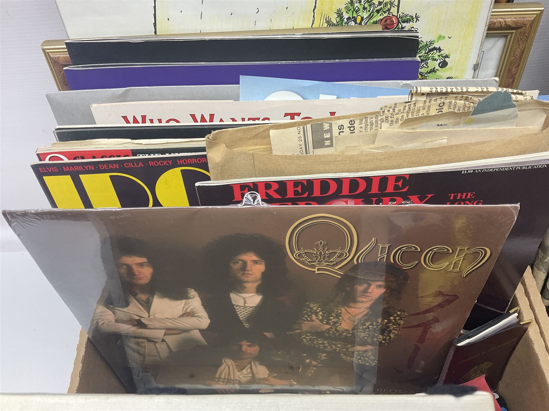 Mostly Queen and Freddie Mercury interest items, including pin badges, newspaper cuttings, diecast 'promotional' vehicles, special edition Pop Rocks figure of Freddie Mercury, VHS tapes, two charity certificates signed by Brian May and Roger Taylor, poster etc, in two boxes 