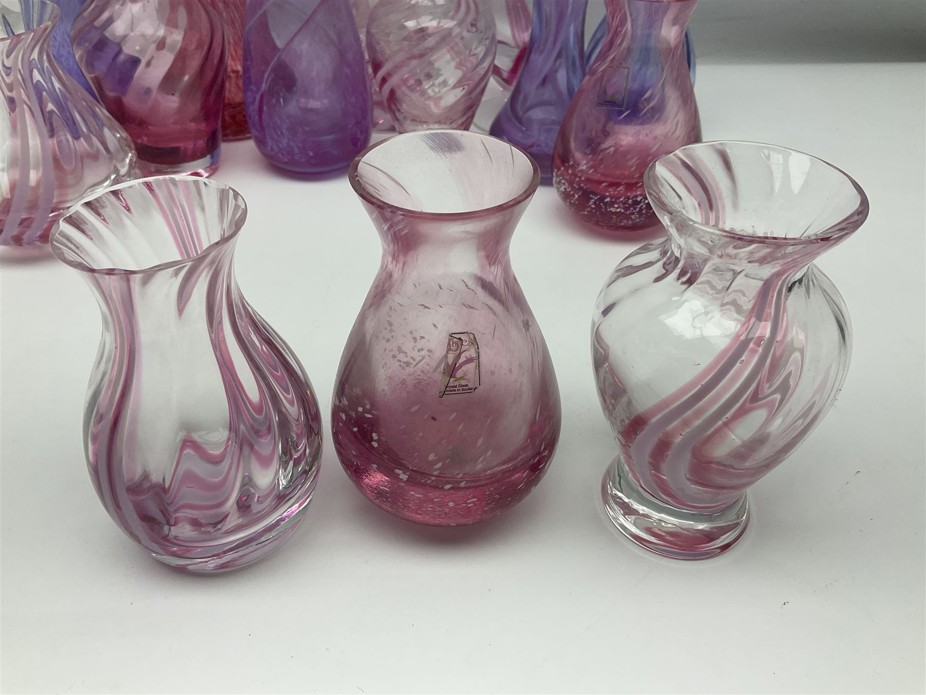 Collection of pink/purple Caithness glass vases, to include mottled and swirl designs, largest 20cm (19)