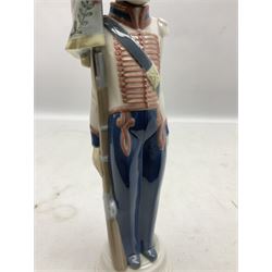 Lladro figure, Flagbearer, modelled as a soldier standing to attention with a flag, sculpted by  Vincente Martinez, no 5405, year issued 1987, year retired 1989, and a Lladro Collectors plaque, soldier H32cm 