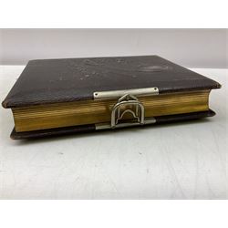 Victorian leather bound photo album, the interior leaves containing apertures of various sizes and shapes of portraits surrounded by printed floral designs, H28cm