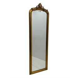 Narrow Victorian design gilt framed wall mirror, anthemion and scrolled acanthus leaf pediment over moulded frame, plain mirror plate 