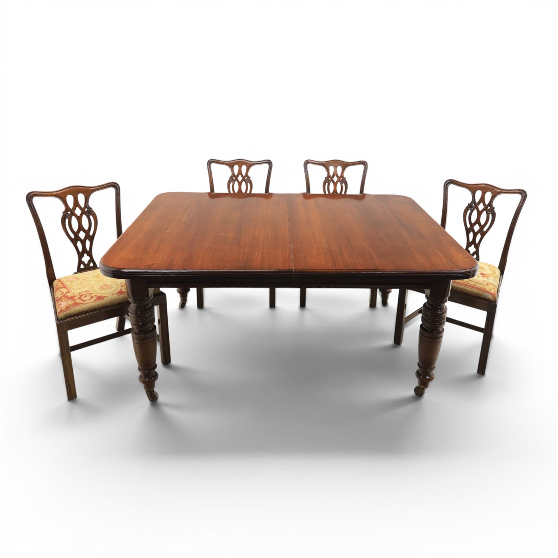 Large 19th century mahogany extending dining table with set of Chippendale design chairs, extending dining table with rectangular moulded top additional three leaves, raised on turned supports terminating in brass castors, the dining chairs (2 + 2) with shaped cresting rail and pierced splats, raised on square supports with stretchers