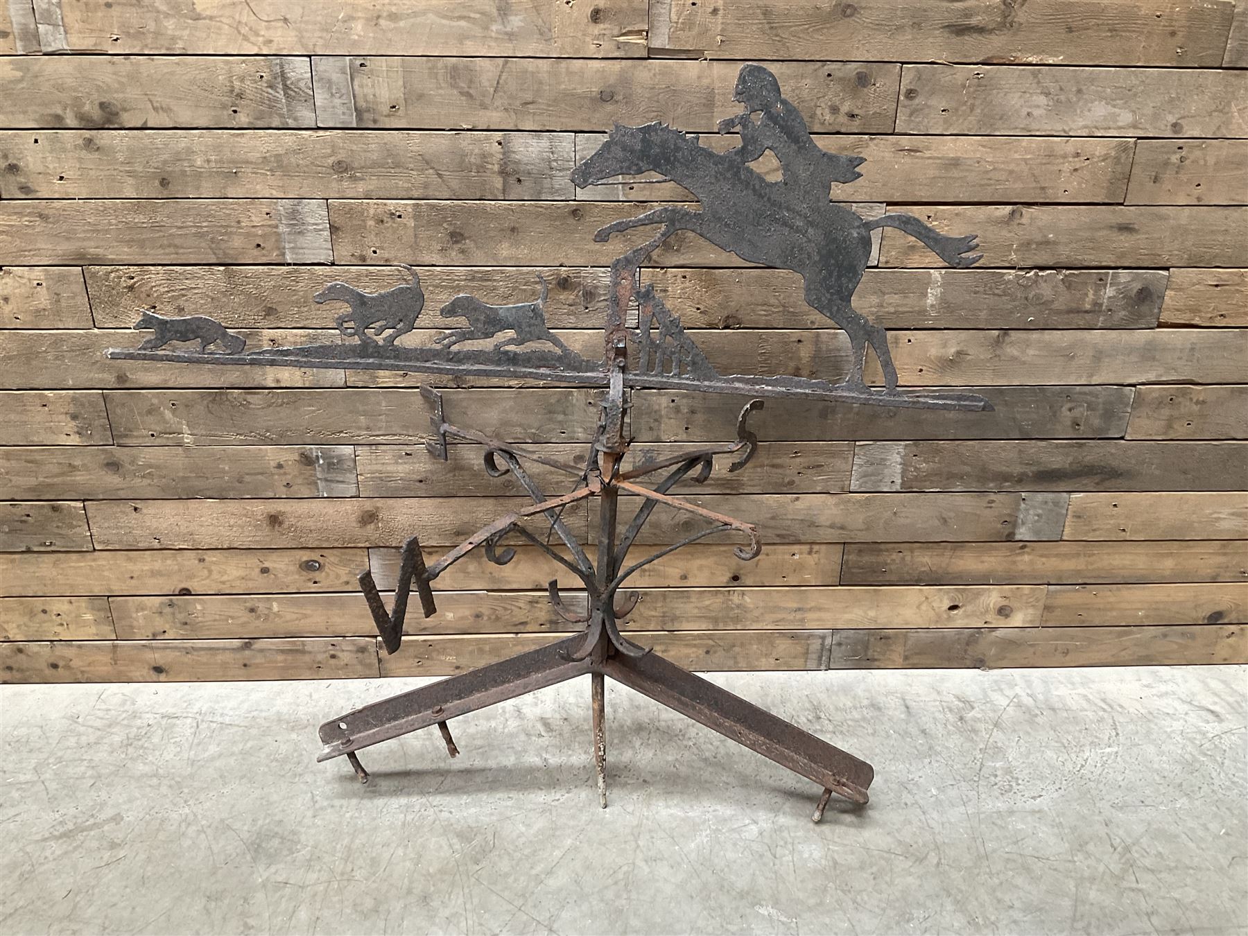 Black painted wrought iron weather-vane depicting hunting scene and compass points