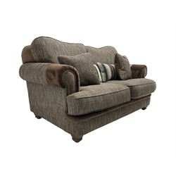 'Canterbury' two seat sofa upholstered in brown fabric with contrasting textures, traditional shape with scrolled arms and studded bands, on turned feet