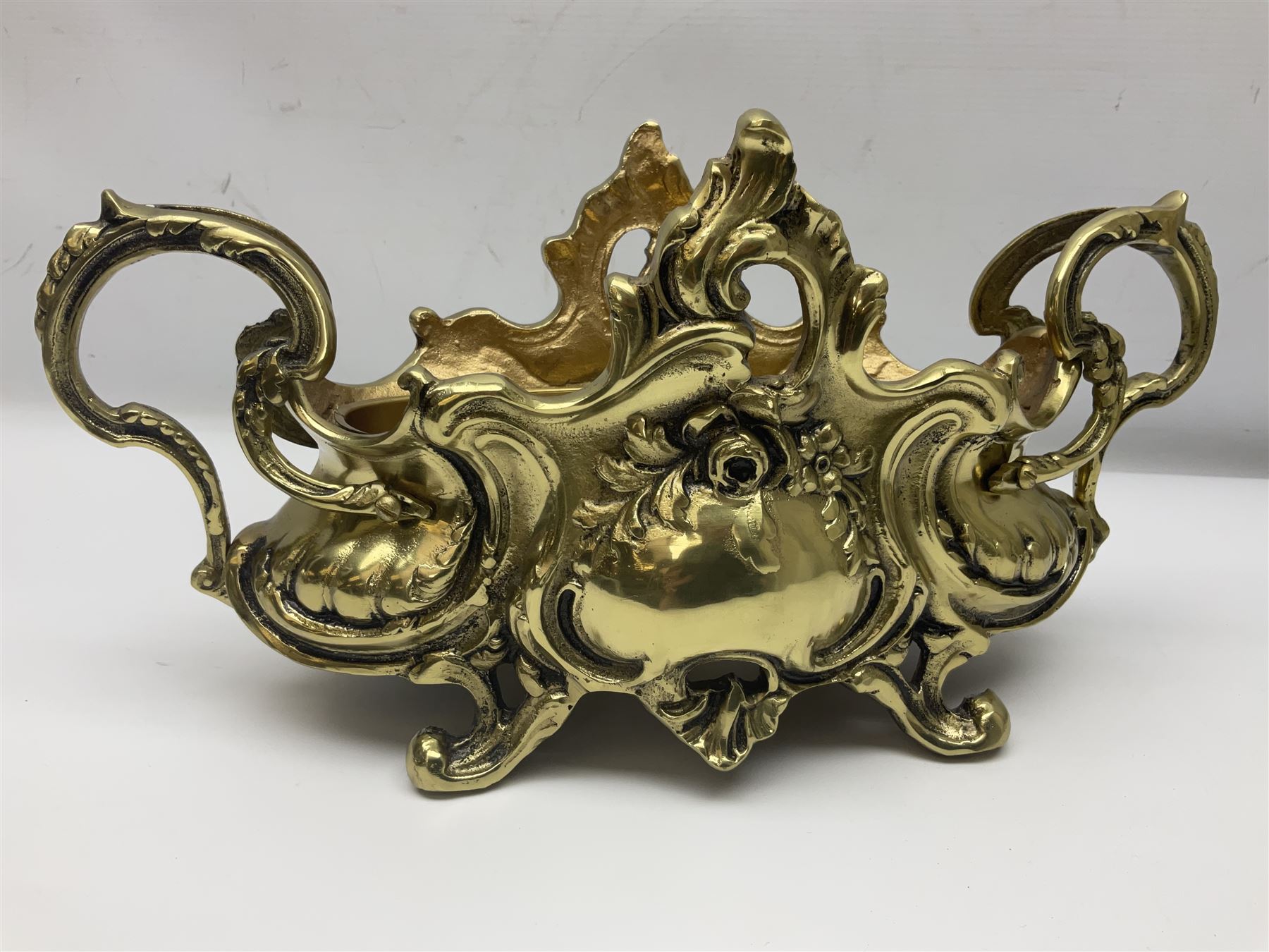 Ornate brass centrepiece, with twin handled vase upon a mirrored base, with floral and scrolling decoration, H23cm 